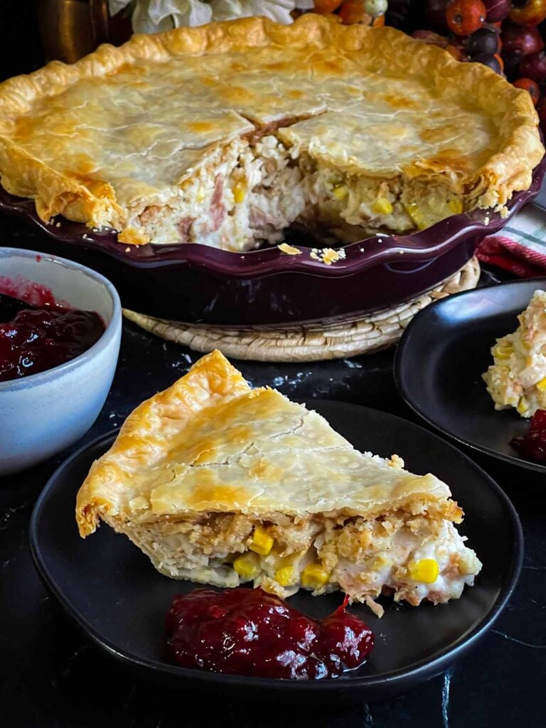 A slice of leftover Thanksgiving pie on a black plate.