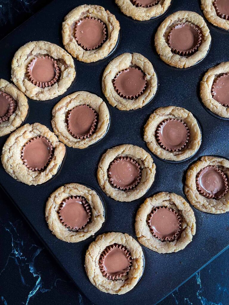 Baked peanut butter cup cookies in a mini muffin pan.