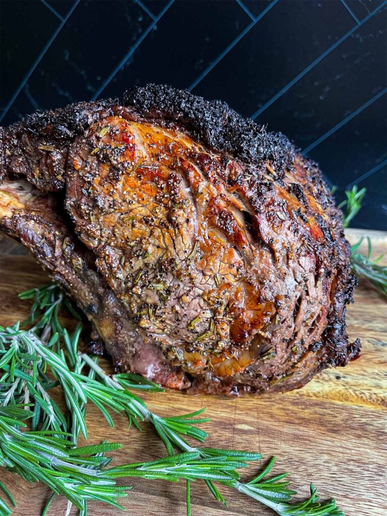 Cooked prime rib on a wooden cutting board.