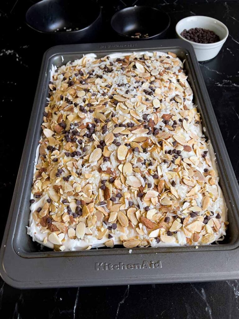 The Almond Joy cake with the shredded coconut, sliced almonds, and mini chocolate chips sprinkled over the top.