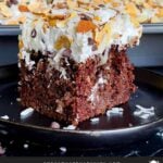 Almond Joy Cake is a rich and decadent chocolate cake, soaked with coconut cream sauce, and topped with sweet coconut, whipped cream topping, almonds, and semi-sweet chocolate chips.