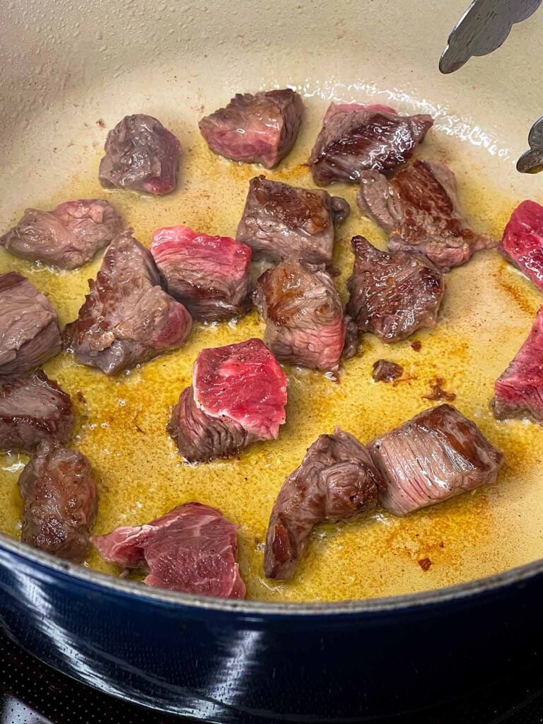 Stew meat browning in a dutch oven.