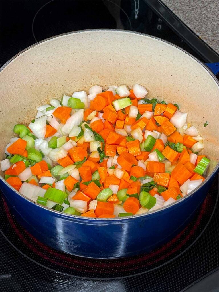 Celery, carrots, and onions added to a dutch oven.