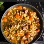 Beef barley soup in a dark bowl.