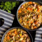 Beef barley soup in a dark bowl.