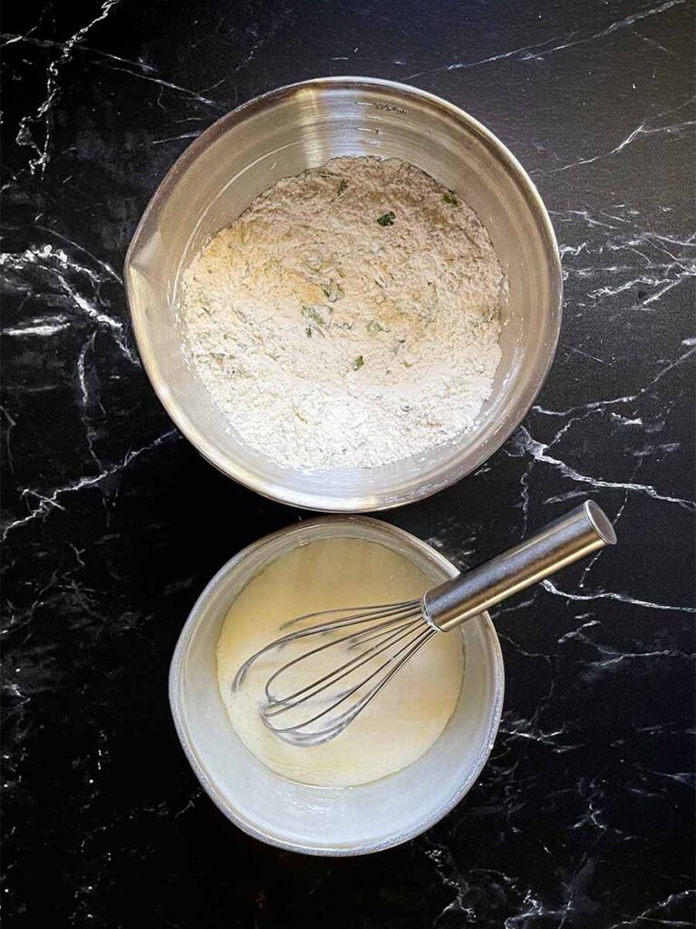 Dumpling ingredients in stainless steel bowls.