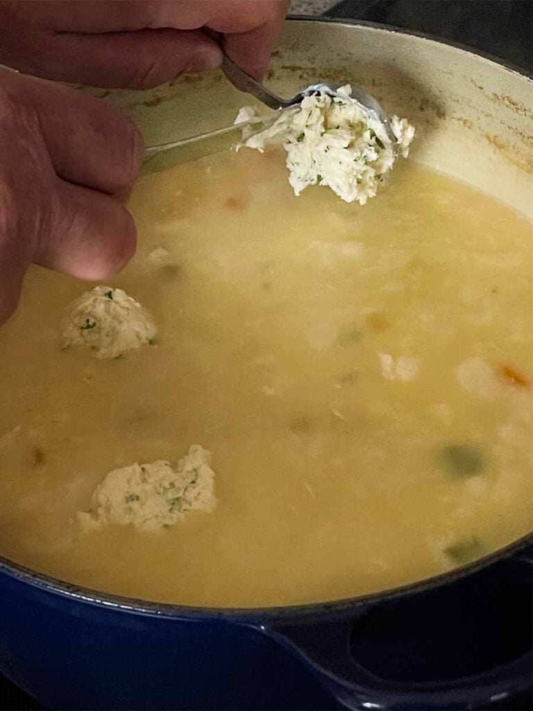 Dropping dumpling dough into the chicken soup.