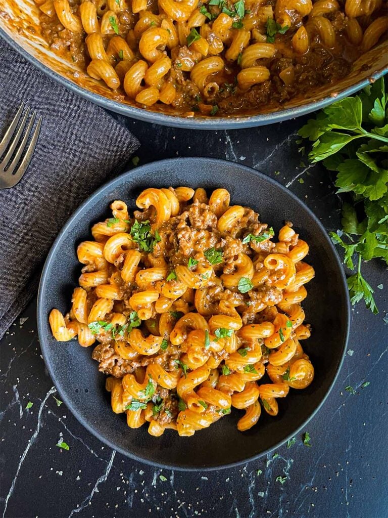 Homemade one pot hamburger helper in a dark bowl.