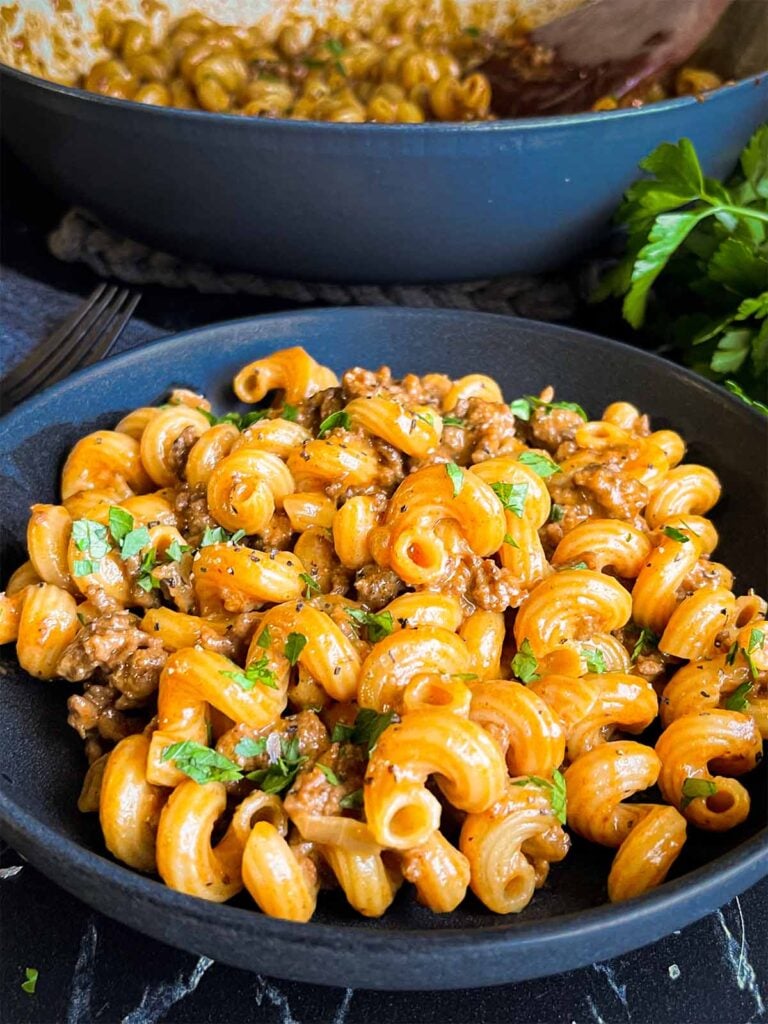 Homemade one pot hamburger helper in a dark bowl.