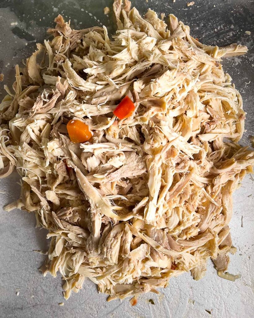 Cooked shredded chicken on a sheet pan.