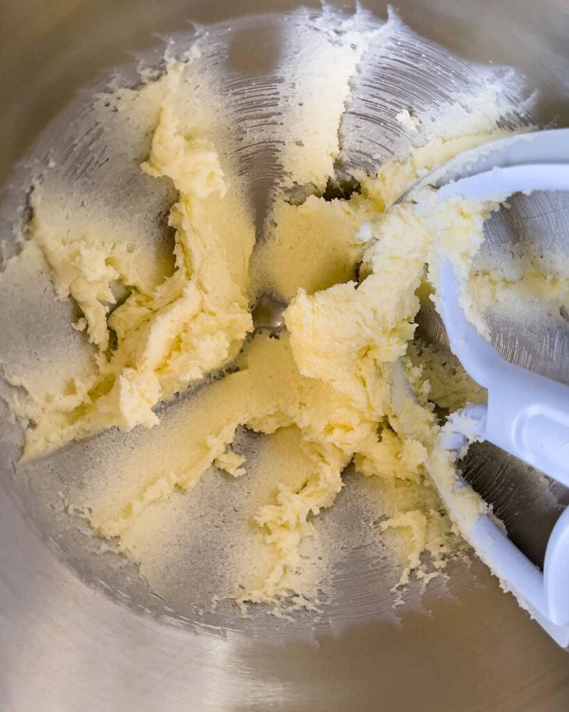 Butter and sugar creamed in a metal mixing bowl.