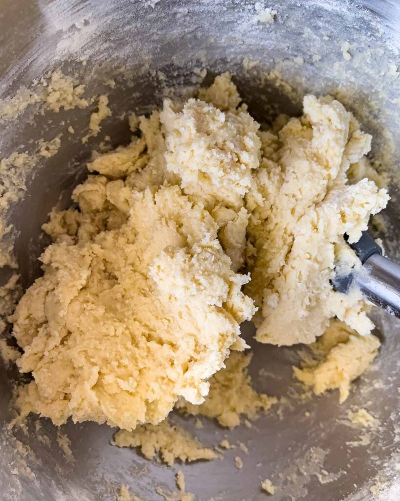 Soft frosted sugar cookie dough in a metal mixing bowl.
