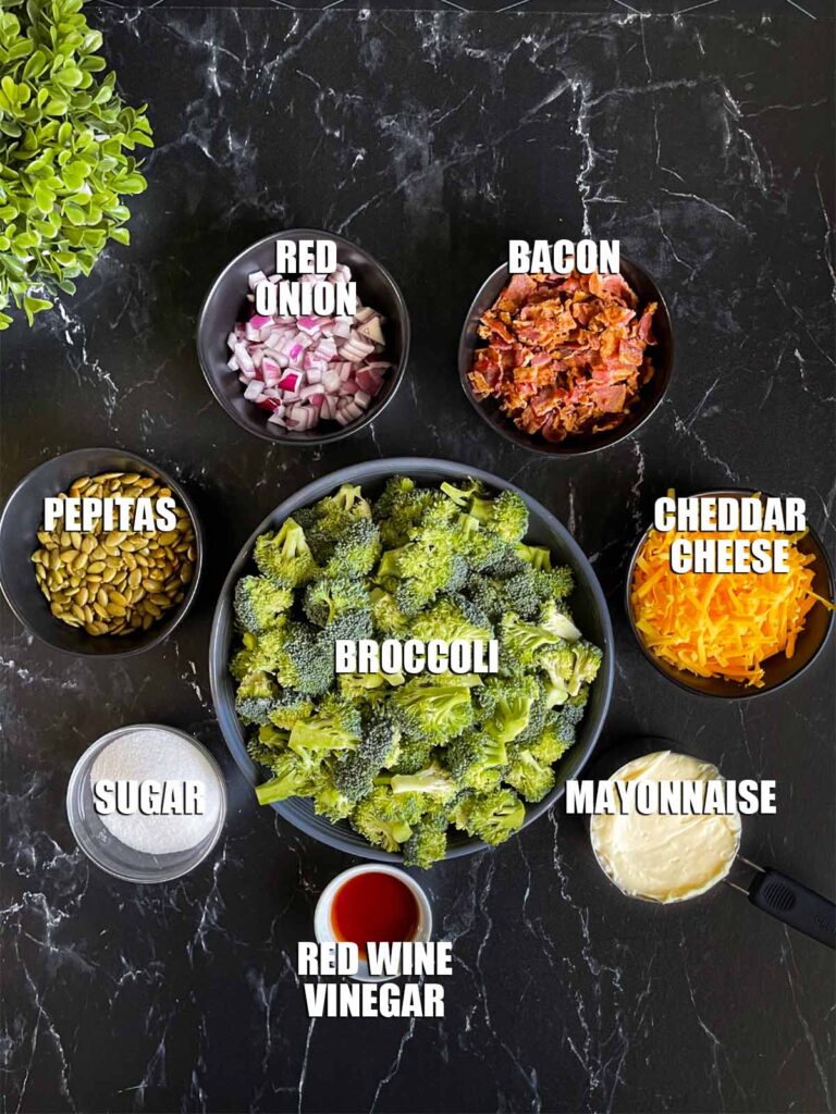 Broccoli salad ingredients on a dark surface.