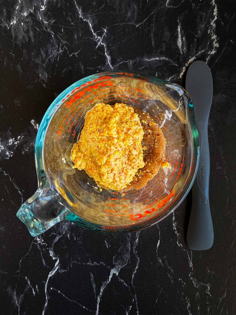 Brown sugar glaze ingredients in a glass measuring cup.