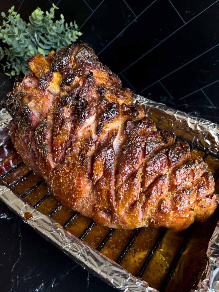 Brown sugar glaze baked on the ham sitting in the roasting pan.