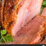 Brown sugar glazed ham on a platter garnished with fresh parsley.