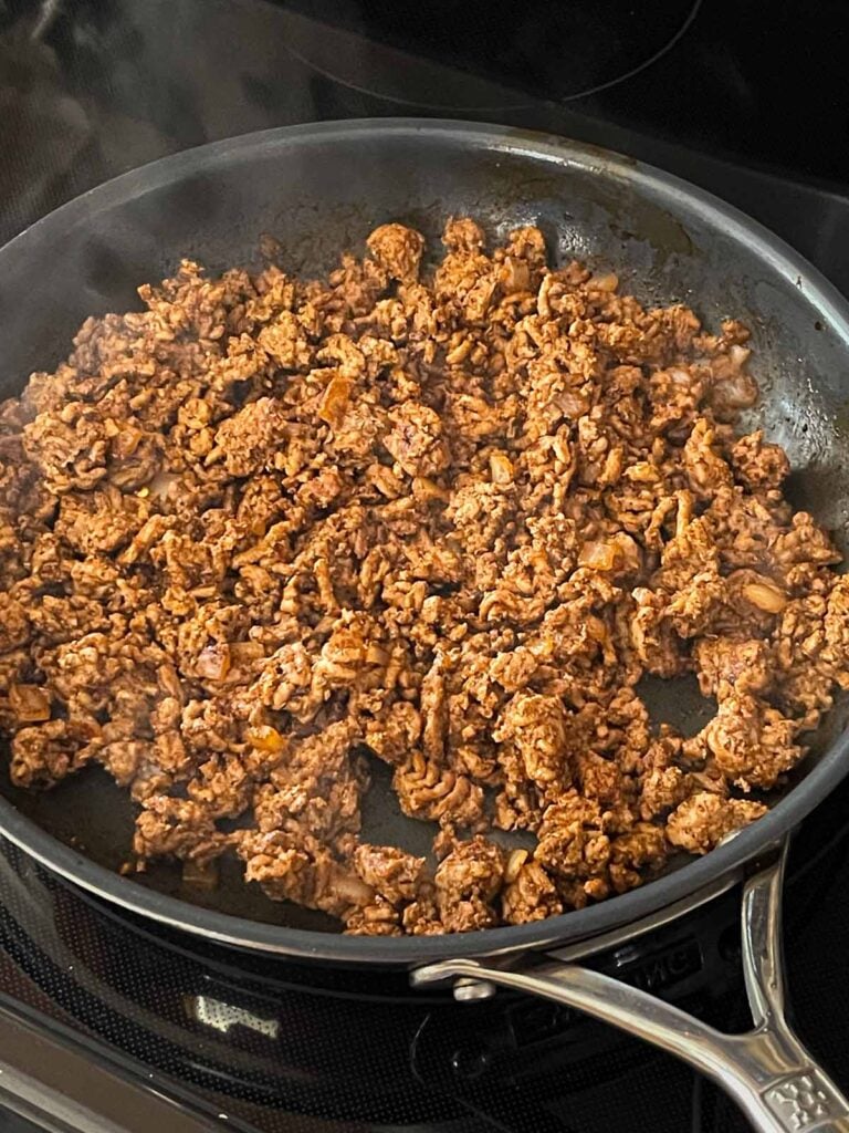 Seasoned ground beef in a skillet.