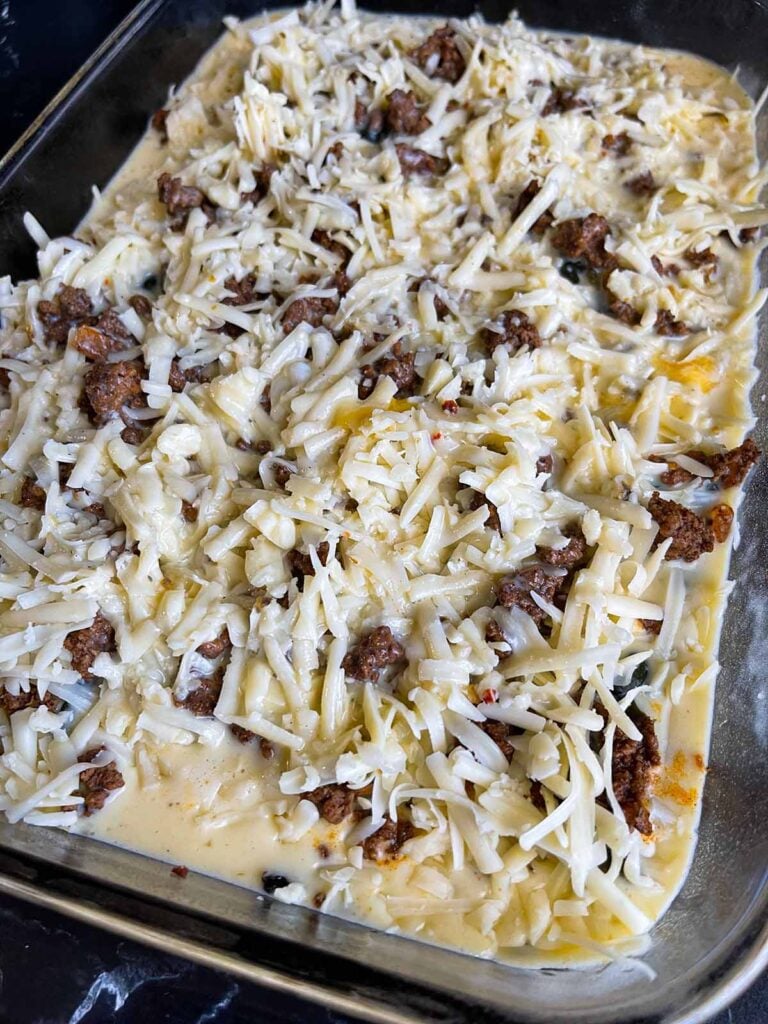 Chile relleno casserole in glass baking dish ready to be baked.