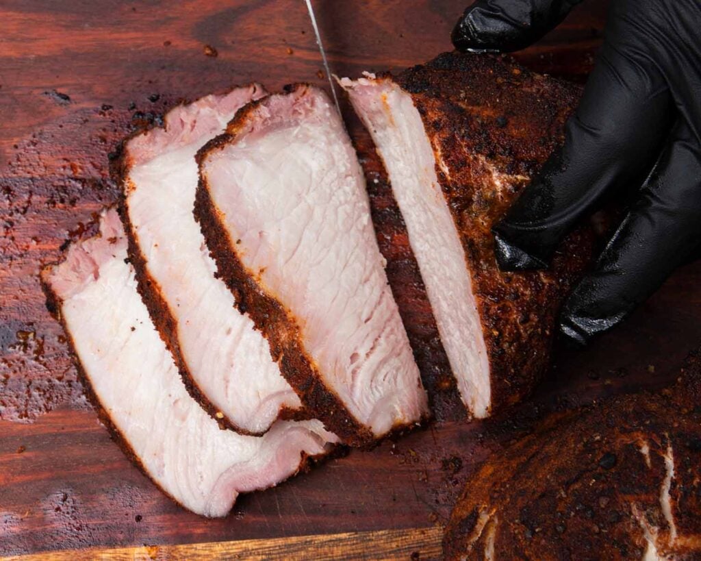 Slices of pork from a pork chop on a cutting board.