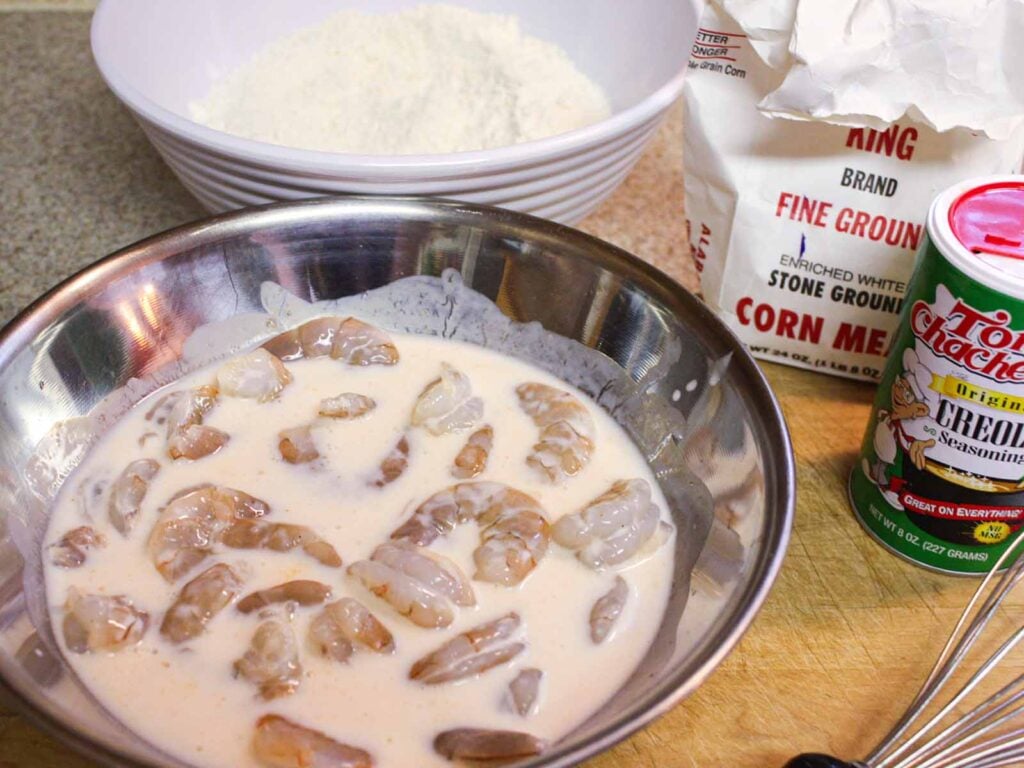 Raw shrimp in the buttermilk mixture.