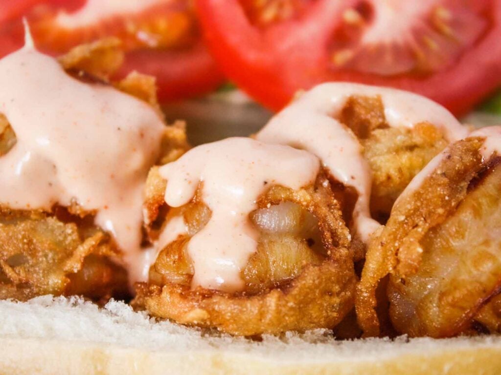 Shrimp po'boy in a brown paper lined red basket.