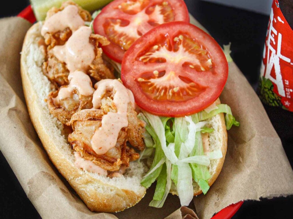 Shrimp po'boy in a brown paper-lined red basket.