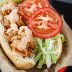 Shrimp po'boy in a brown paper-lined red basket.