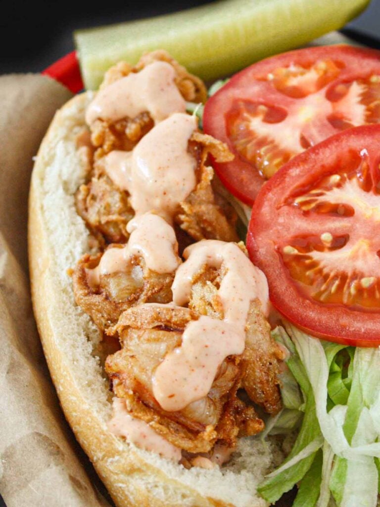 Shrimp po'boy in a brown paper lined red basket.