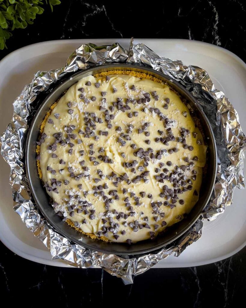 Cannoli cheesecake in the springform pan wrapped with aluminum foil and place inside a large roasting pan.