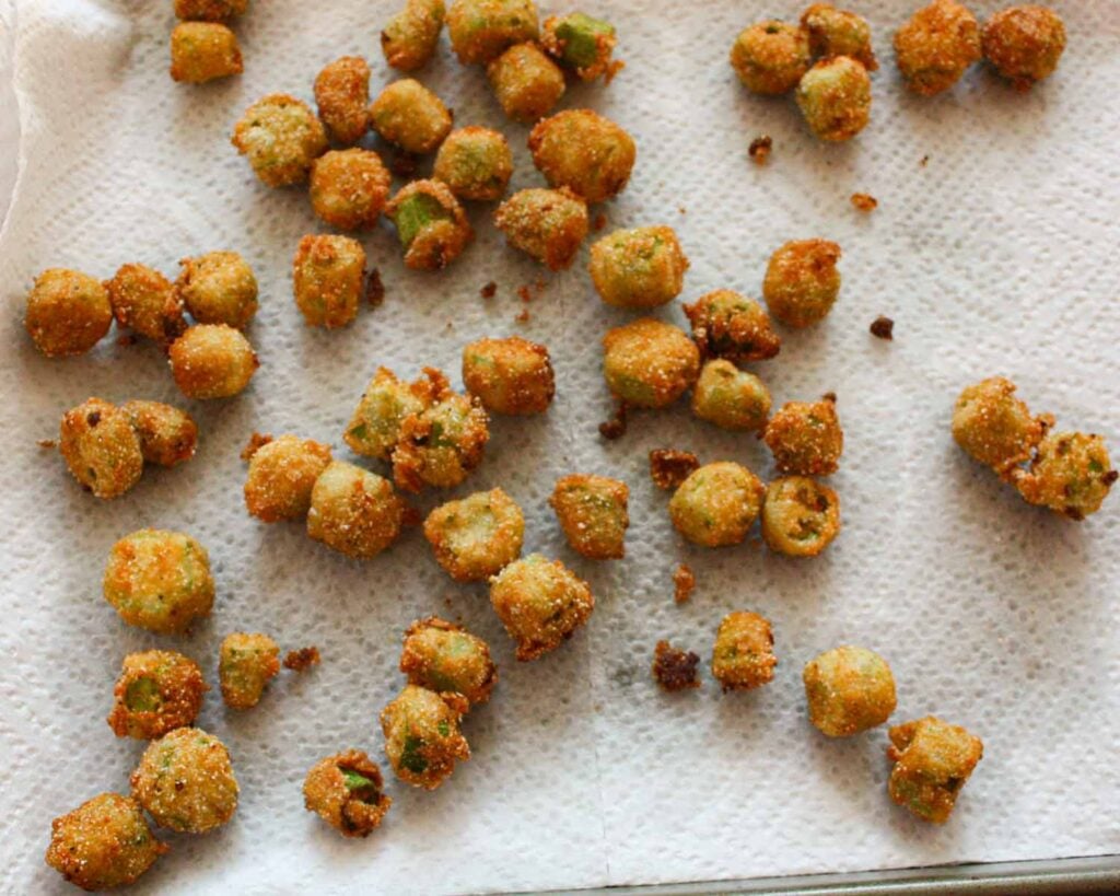Fried okra draining on paper towels.