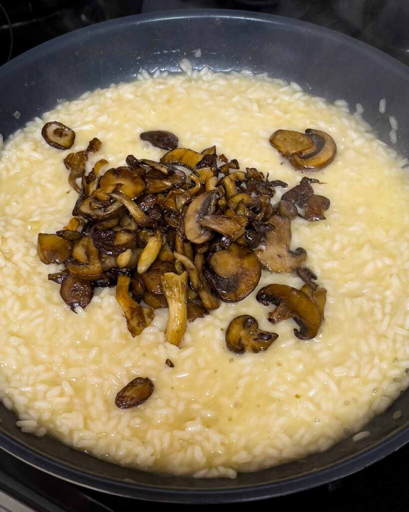 Adding mushrooms to a risotto.