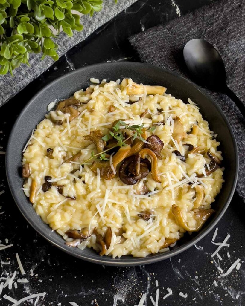 Mushroom risotto in a dark bowl.