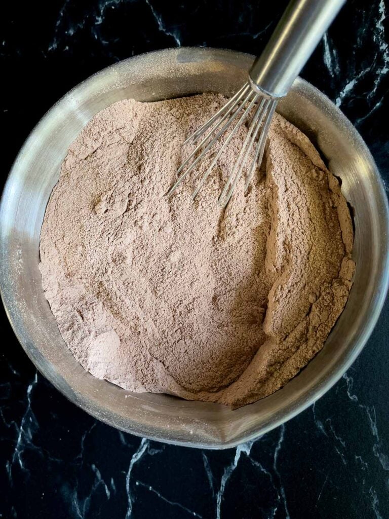 Dry ingredients for Mississippi Mud Cake whisked together in a metal bowl.
