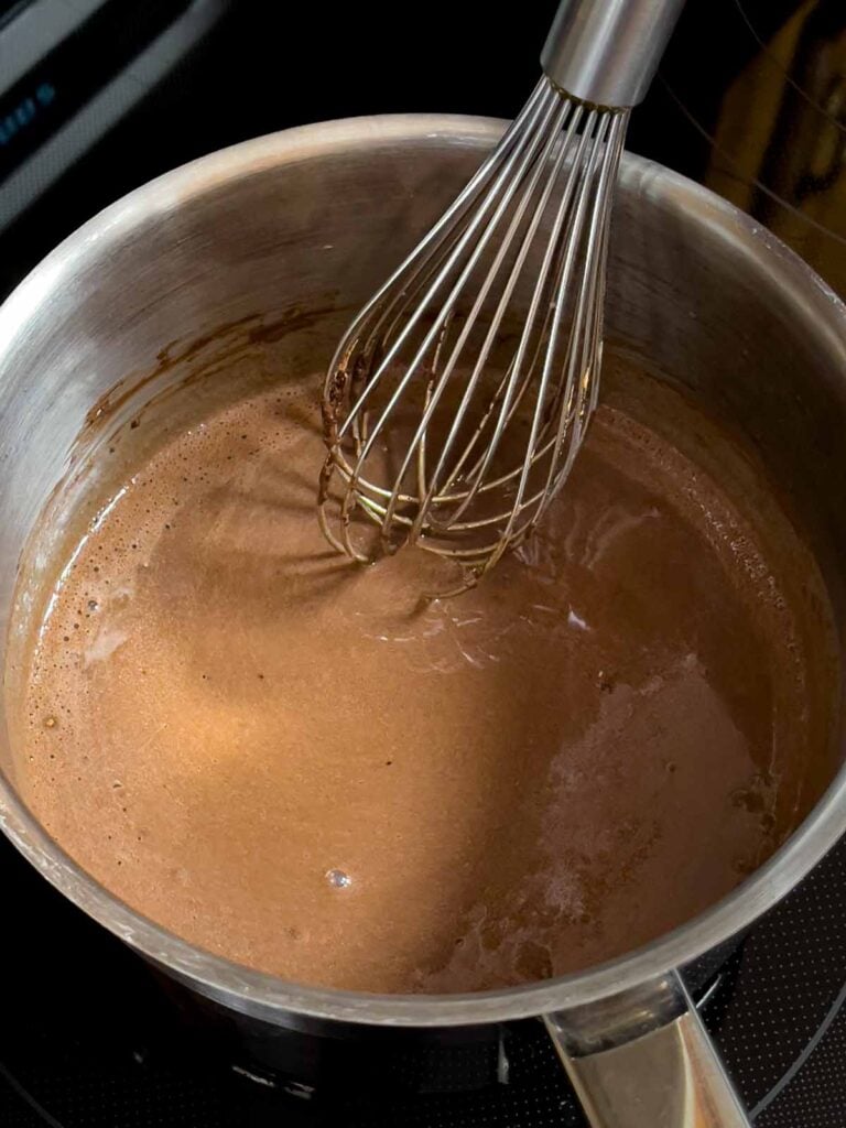 Chocolate frosting for the Mississippi Mud Cake in a metal sauce pan.