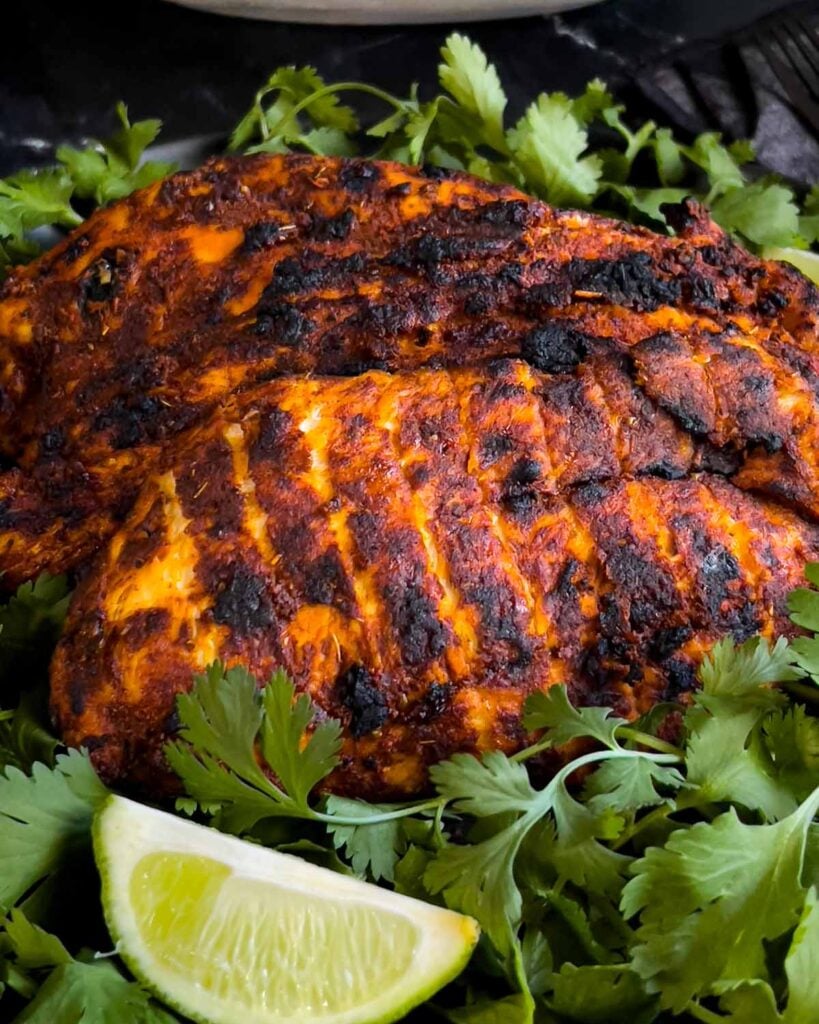Mexican grilled chicken breast (pachuga asada) on a bed of cilantro.