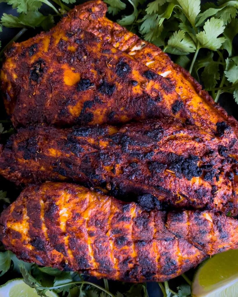 Mexican grilled chicken breast (pachuga asada) on a bed of cilantro.