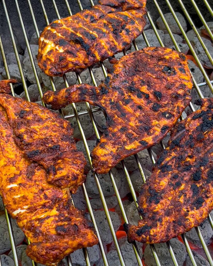 Mexican grilled chicken breast (pechuga asada) on the charcoal grill.