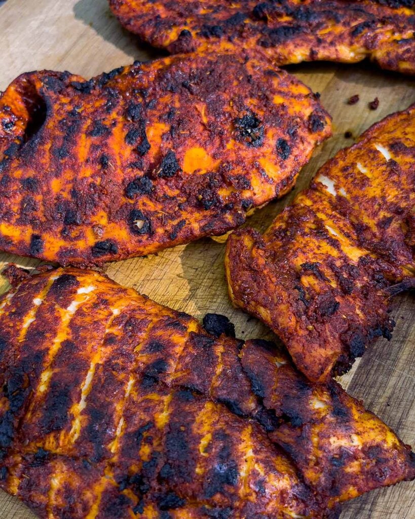 Grilled Mexican chicken breasts right off the grill, resting.