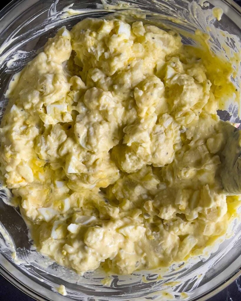 Southern potato salad combined in a glass mixing bowl.