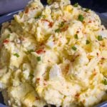 Southern potato salad in a bowl garnished with chives and paprika.