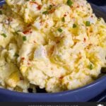 Southern potato salad in a bowl garnished with chives and paprika.