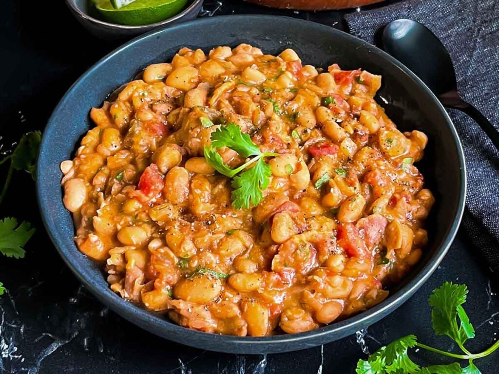 Borracha beans (drunken beans) in a dark bowl.