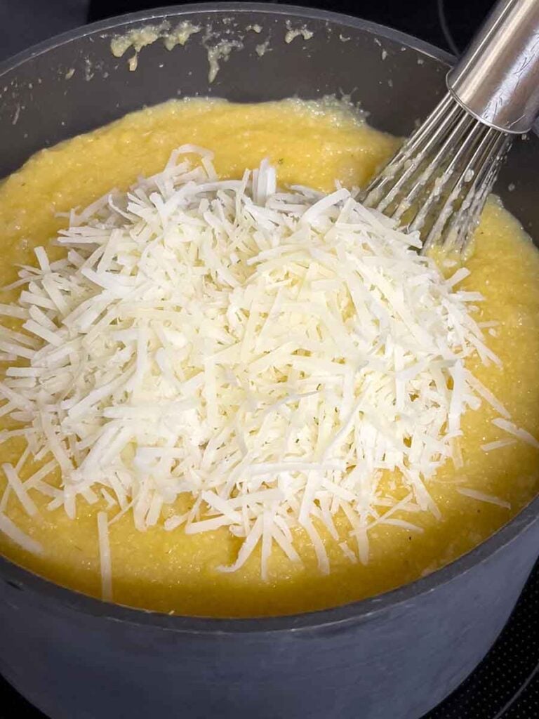 Adding parmesan cheese to polenta.