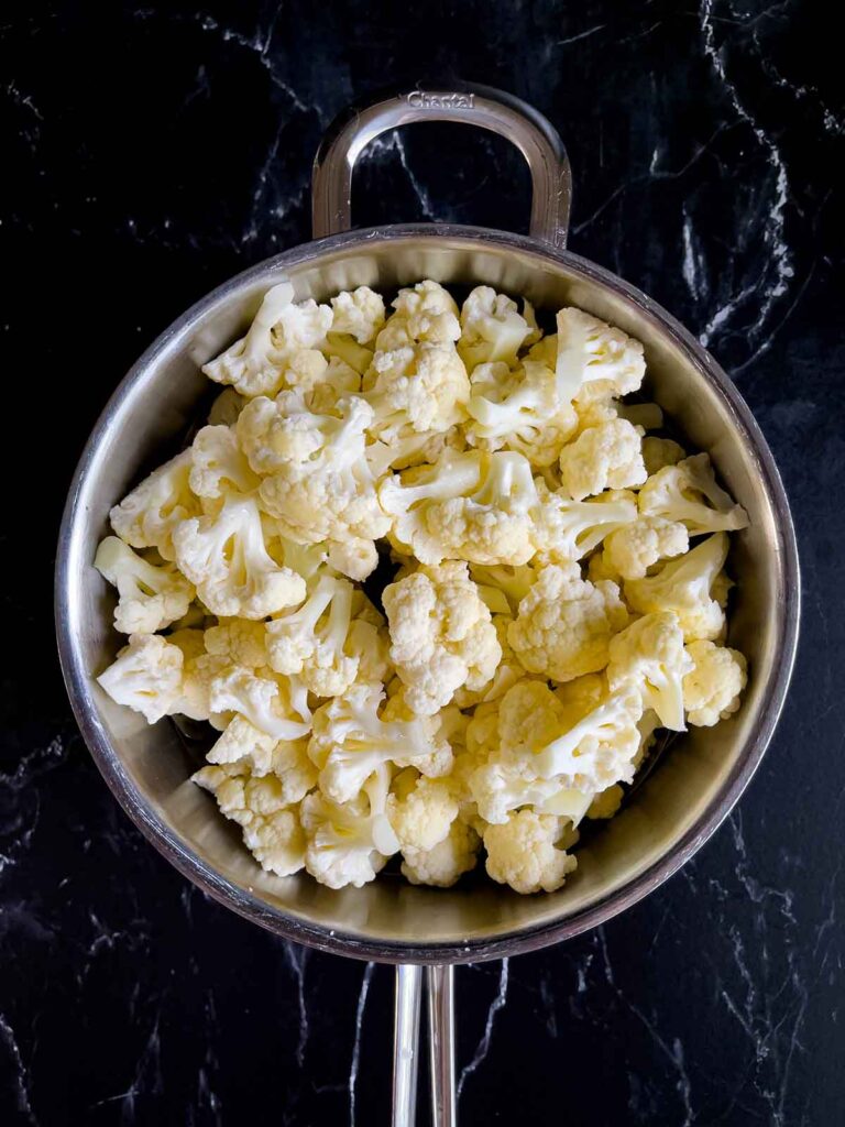 Cut cauliflower in a large pot.