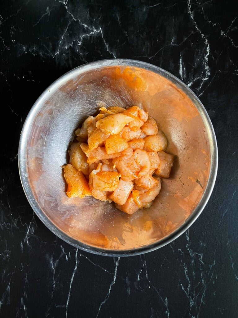 Cut up chicken breast seasoned with cajun seasoning.