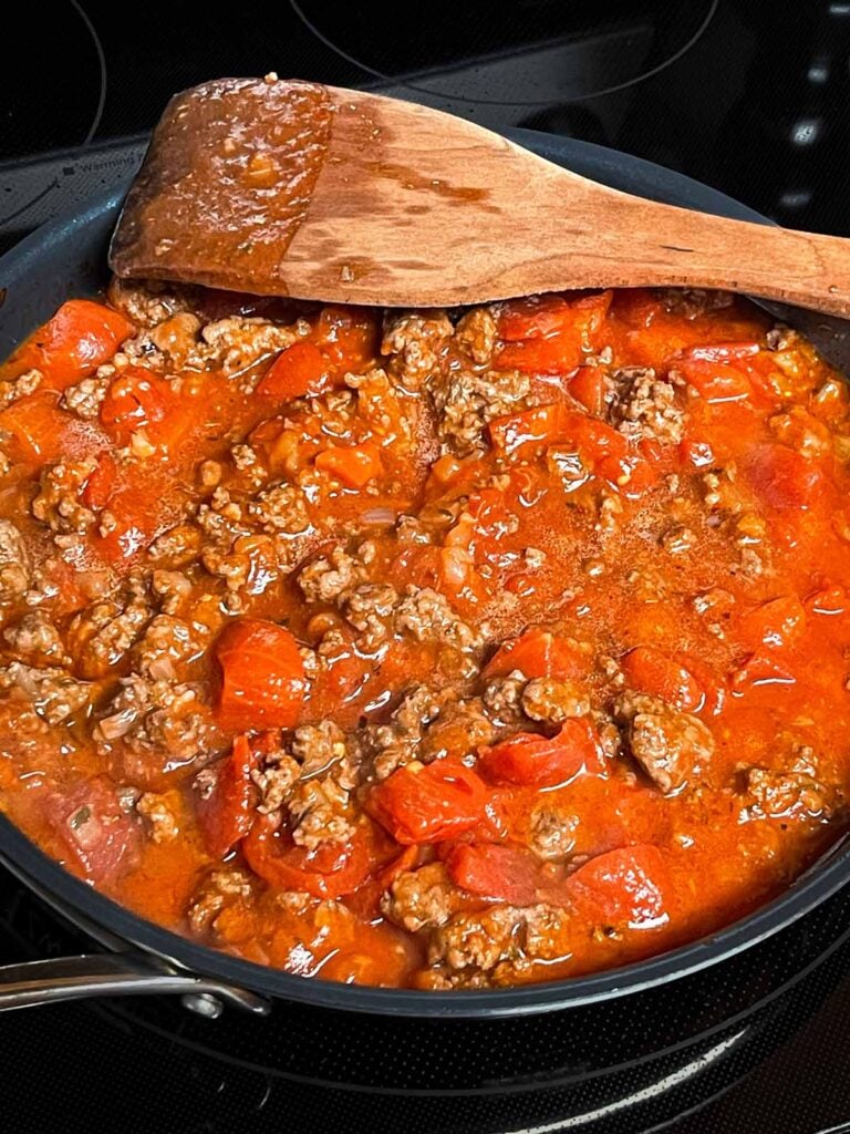 A large skillet filled with a beefaroni mixture.