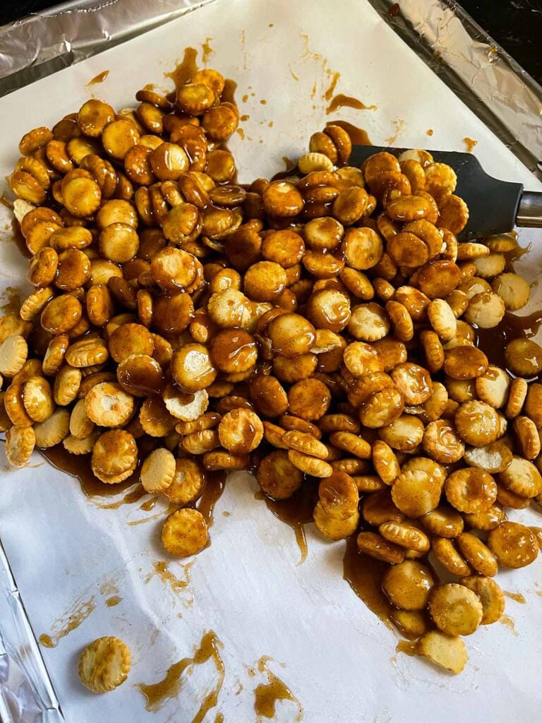 Toffee mixture on oyster crackers on a baking sheet.