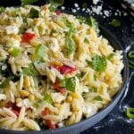 Spinach and Feta Orzo Salad in a dark bowl on a dark surface.