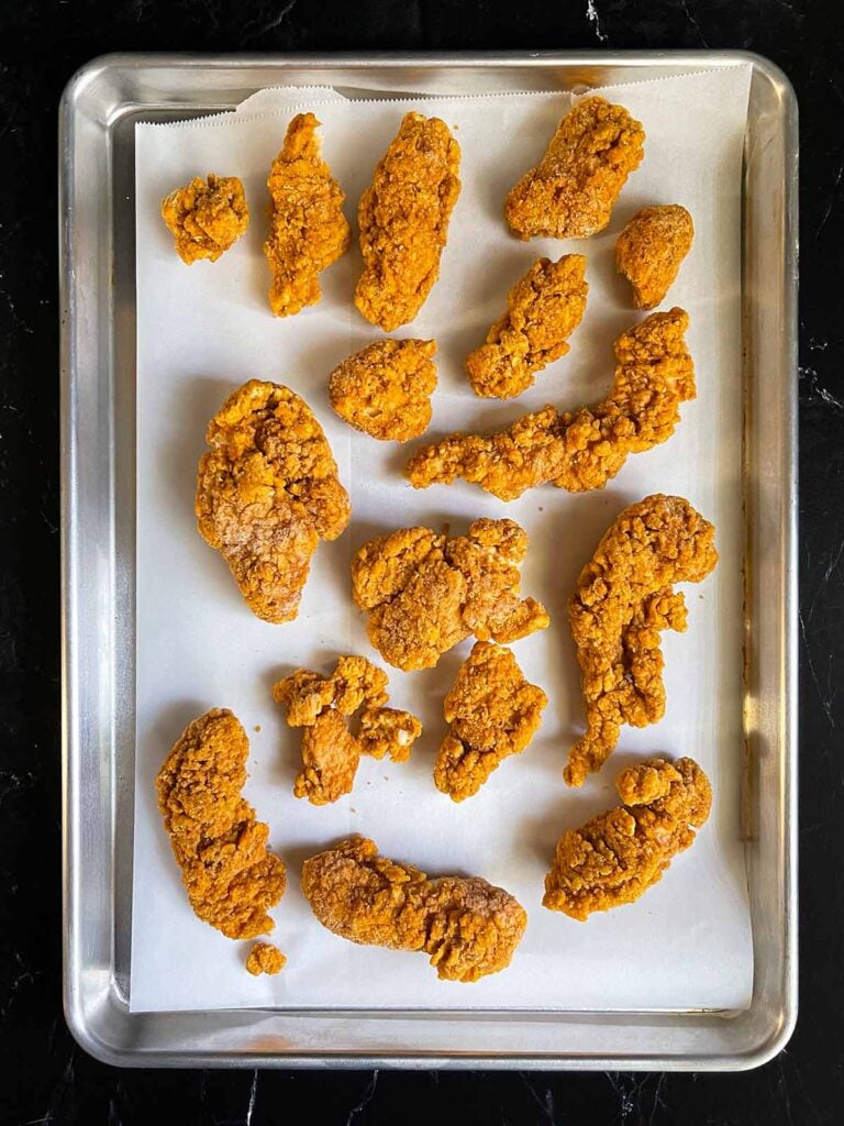 Chicken tenders on a baking sheet.