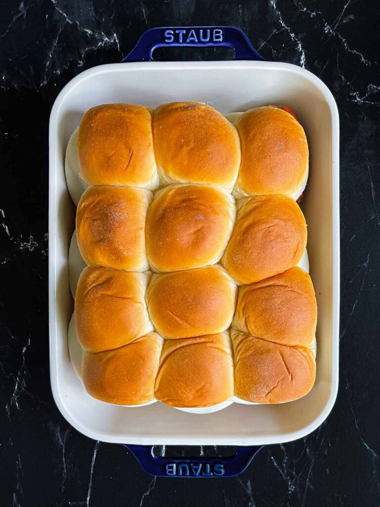 Chicken parmesan sliders assembled in a 9x13 inch baking dish.